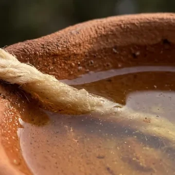 मिट्टी का दीपक, घी और रुई की बाती का क्लोज-अप